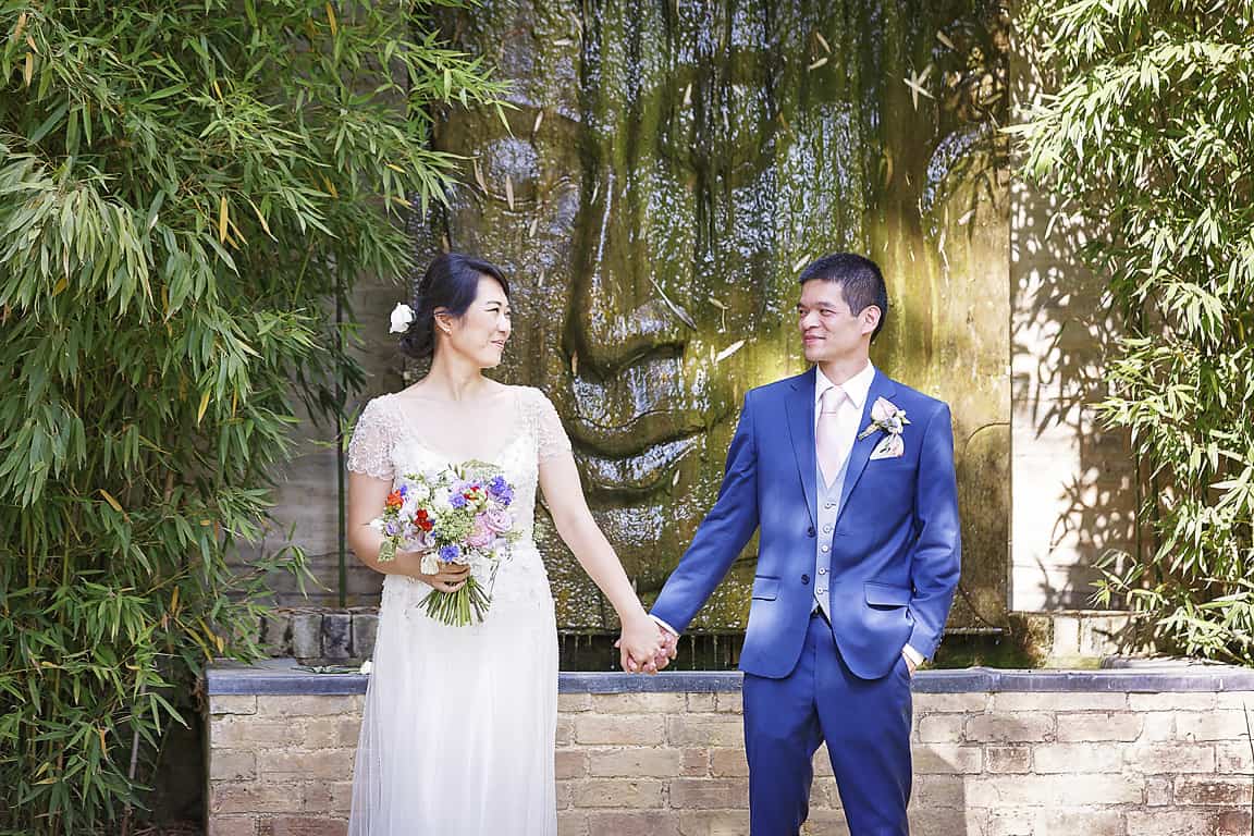 Bride and Groom in front of Buddha water feature at South Farm