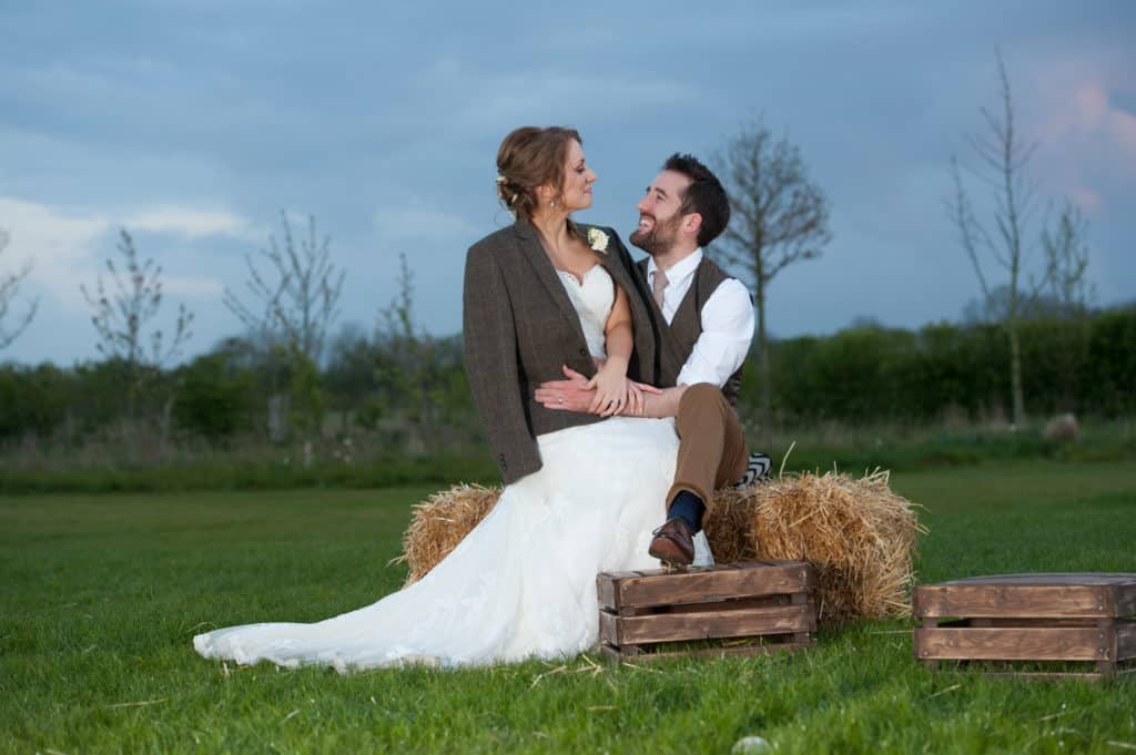 Spring Wedding at South Farm Couple on Hay Bales