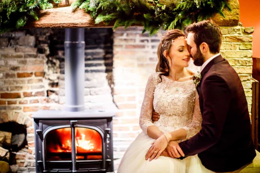 Winter Wedding South Farm Bride and Groom in front of warming log burner