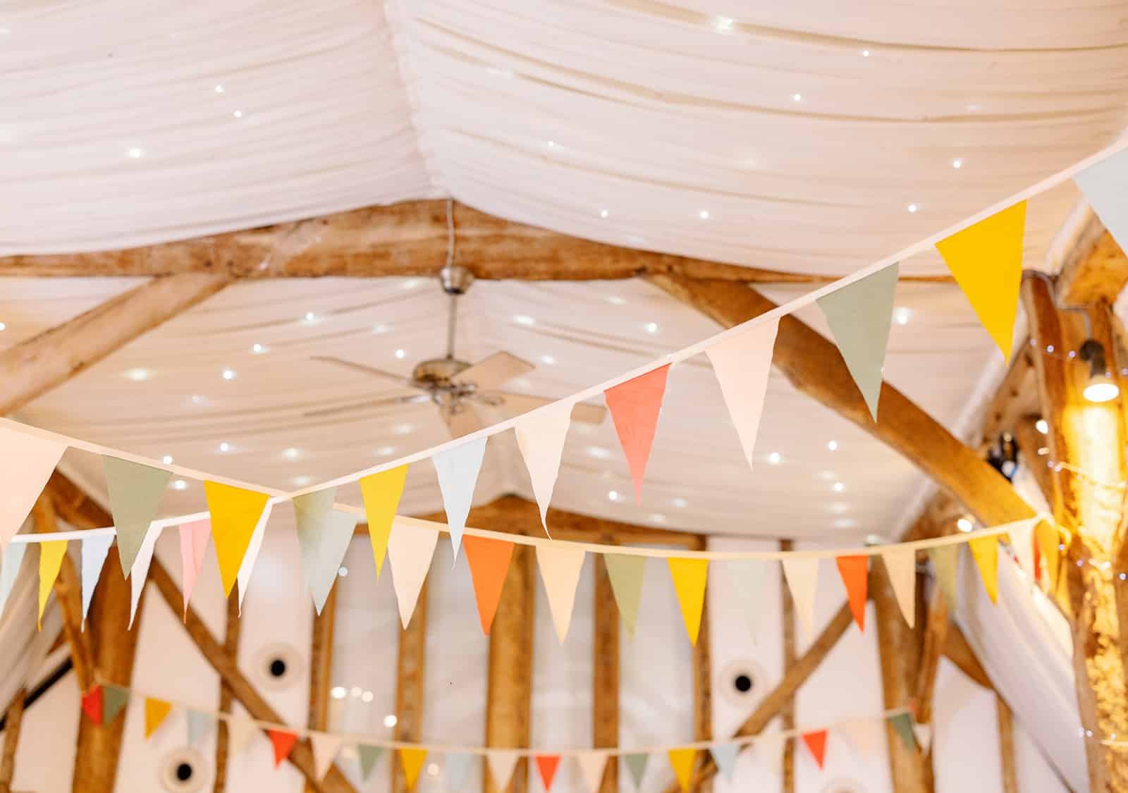 Bright colourful Spring bunting in the Tudor Barn at wedding venue based cambridshire