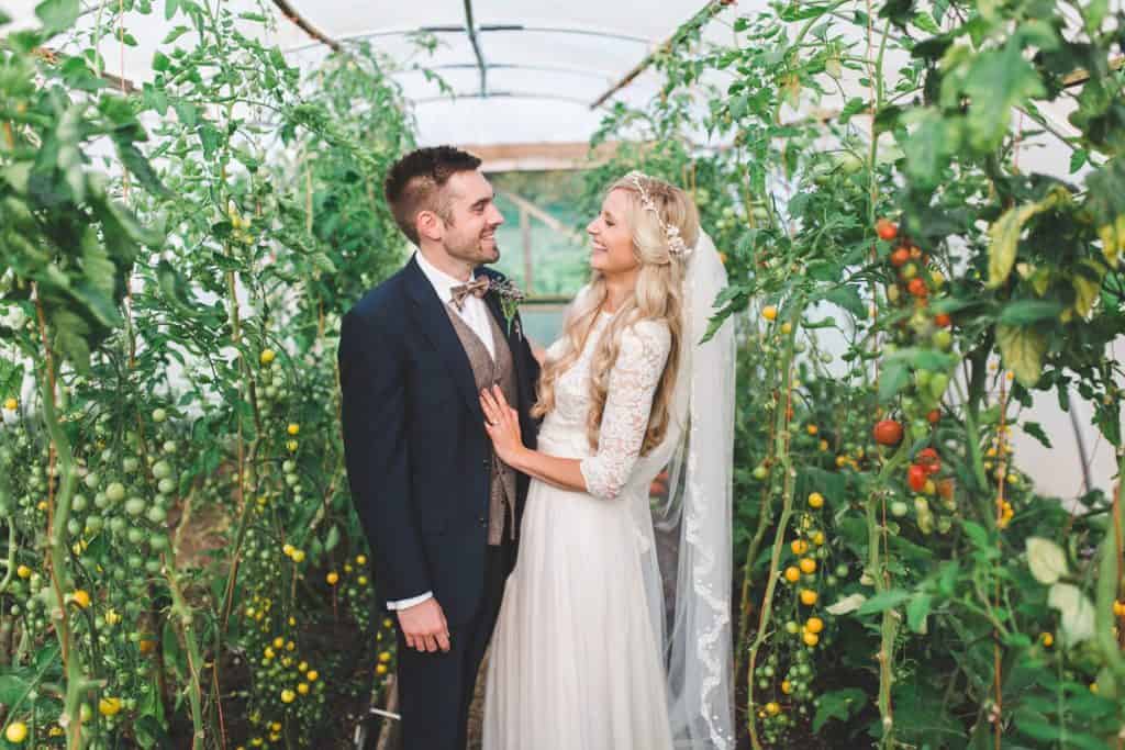 Bride and Groom at Farm Wedding Venue in greenhouse with tomato plants
