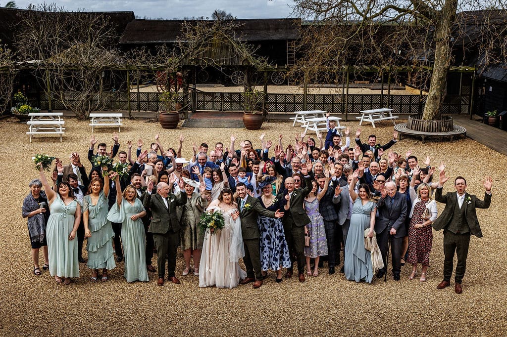 Bride and groom with groom of wedding guests in courtyard of country house wedding venue