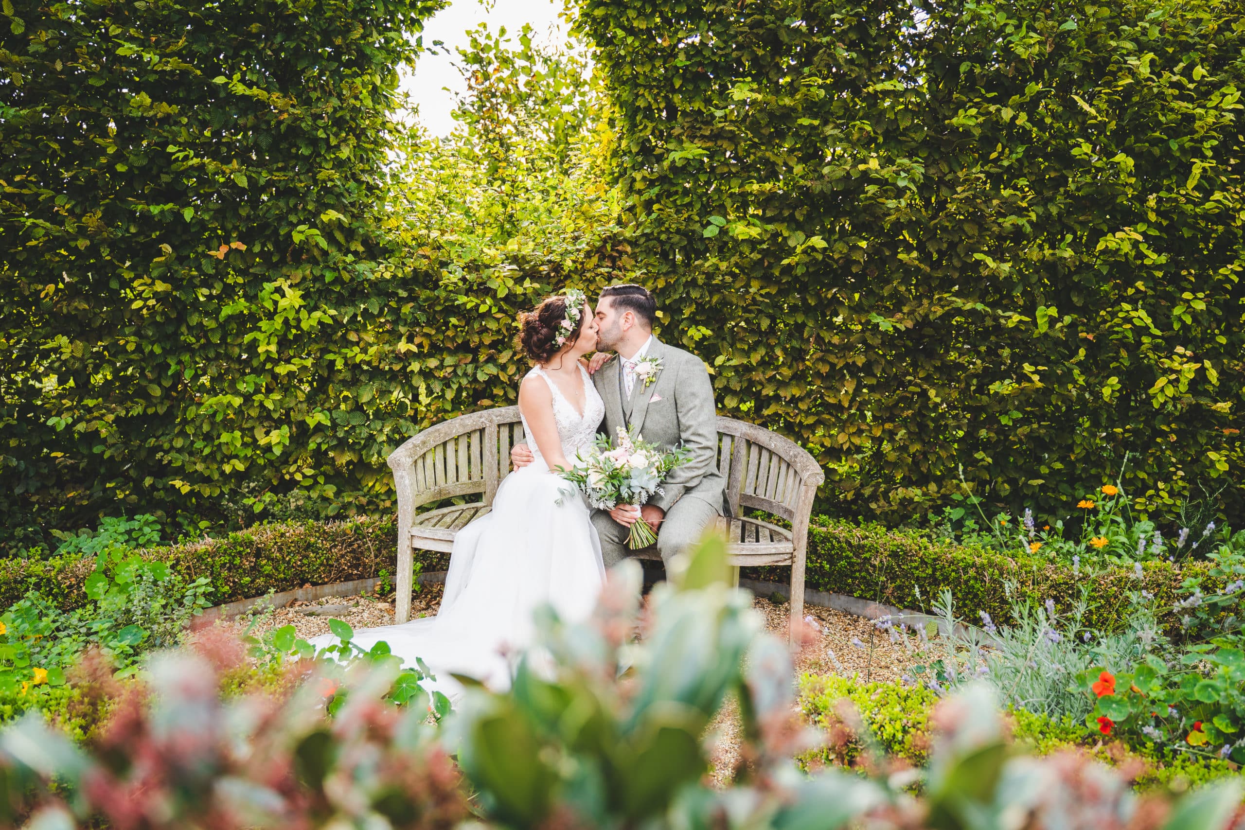 Couple kiss in Herb Garden at Rustic Farm Wedding Venue Cambridgeshire