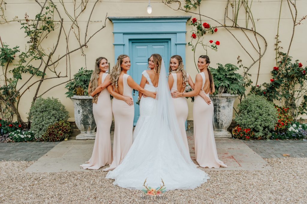 Bride and Bridesmaids smile for photograph in front of Cambridgeshire Wedding Venue