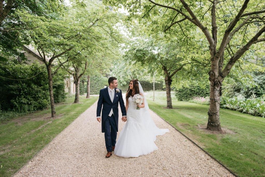 Bride and Groom in tree lined driveway at countryside wedding venue