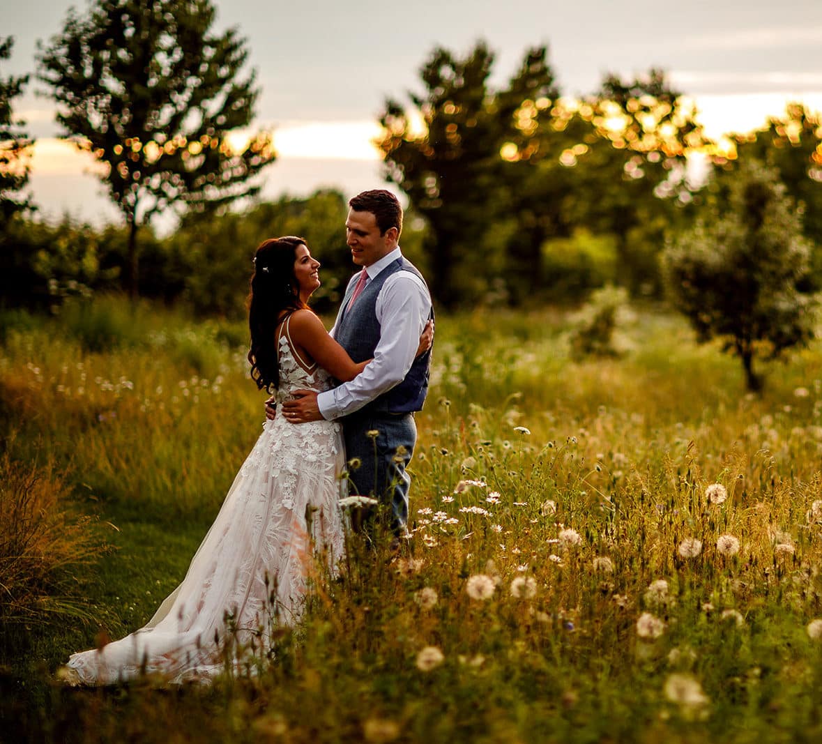 Bride and Groom in wildflower meadow at sunset