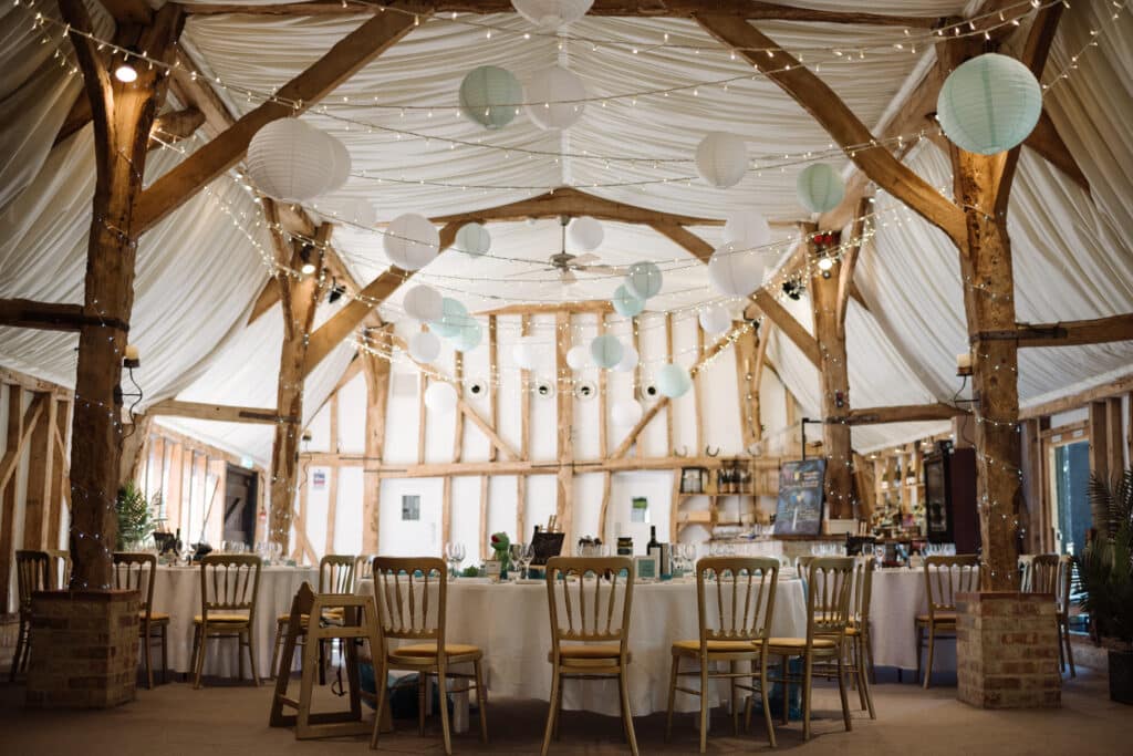 Beautiful Barn Wedding venue set for dining with white lantern decorations
