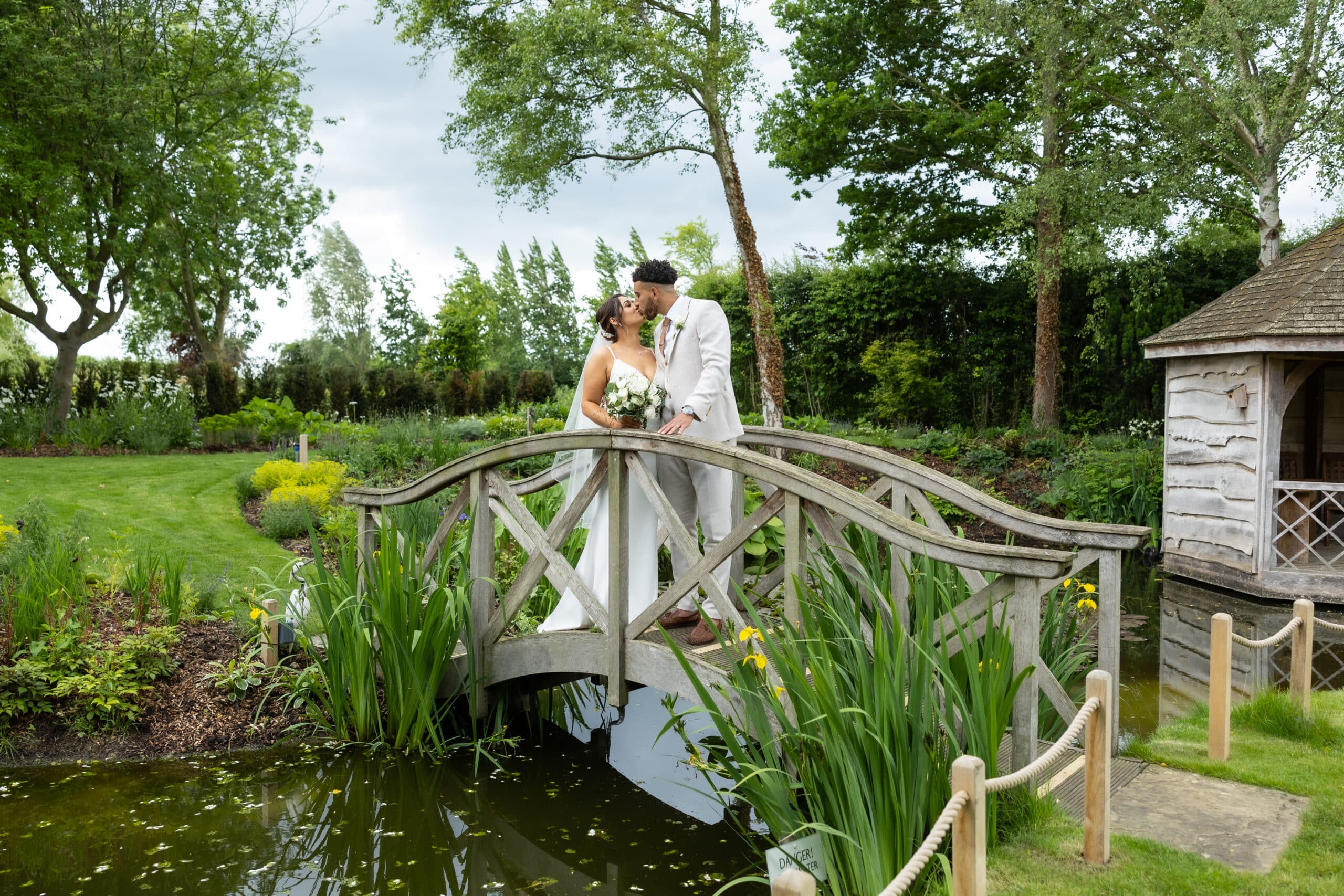 Couple on garden bridge in beautiful countryside wedding venue