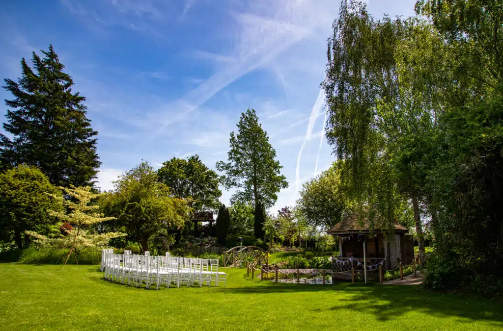Garden set for ceremony with white chairs and blue skys