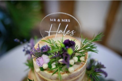Wedding Cake at rustic barn wedding venue with purple flowers and mr and mrs cake topper 