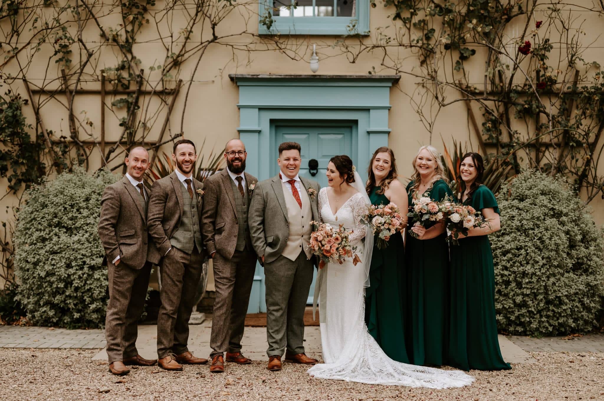 Bridal Party in Autumn Colours in front of countryhouse wedding venue