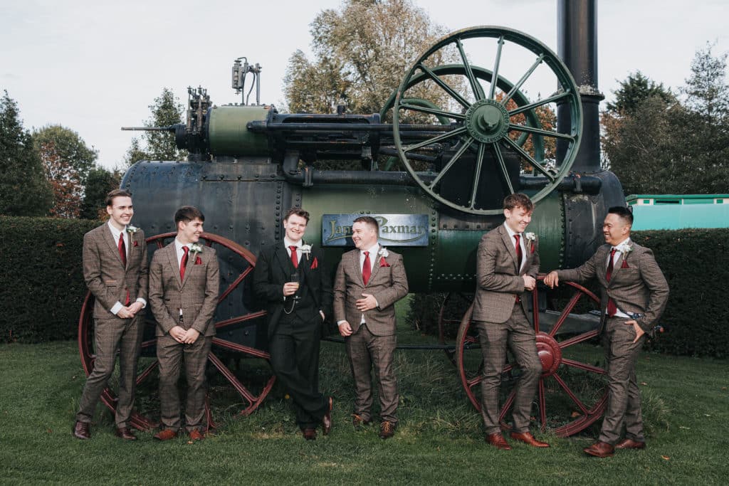 Groom and Groomsmen in front of vintage steam engine at Cambridgeshire wedding venue