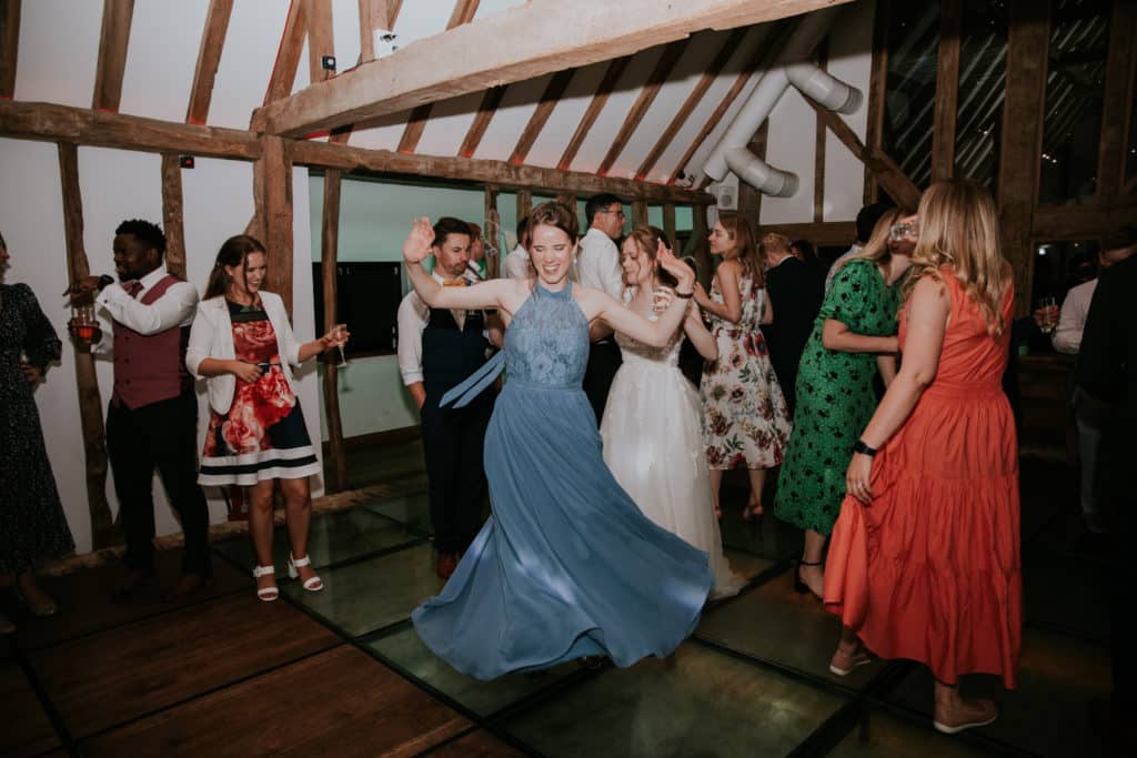 Bridesmaids and guests dance at barn wedding venue evening wedding party 