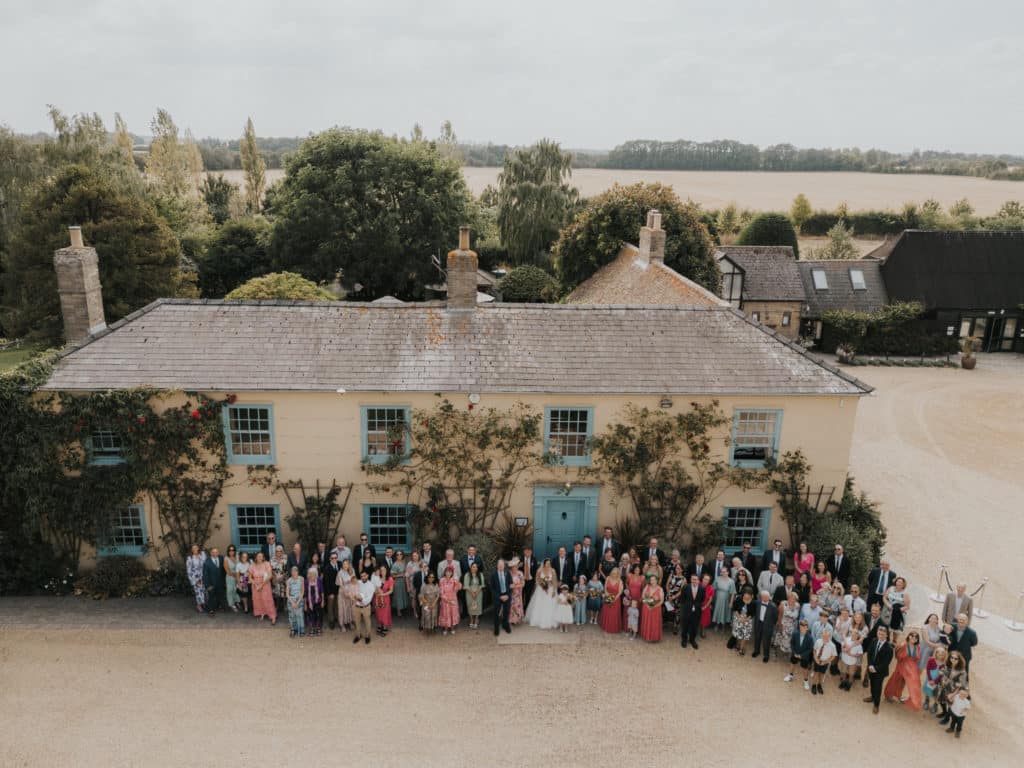 Group photo at countryside wedding venue featuring the bride and groom and all their wedding guests