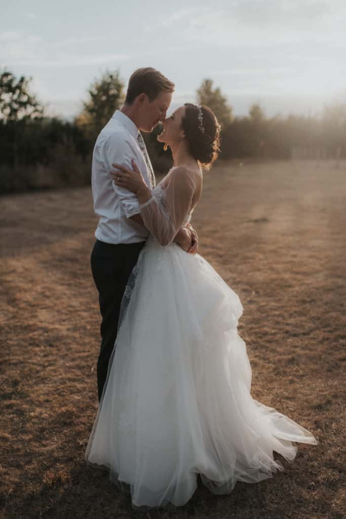 Bride and Groom sunset wedding photo in meadows at farm wedding venue