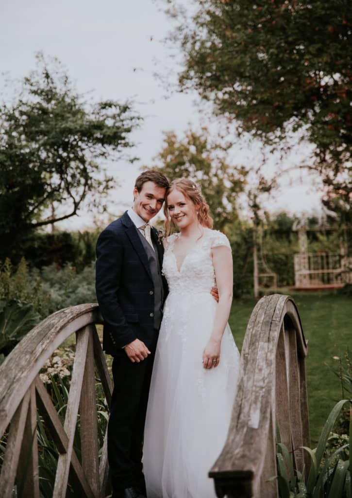 Bride and Groom on garden bridge at countryside wedding venue 