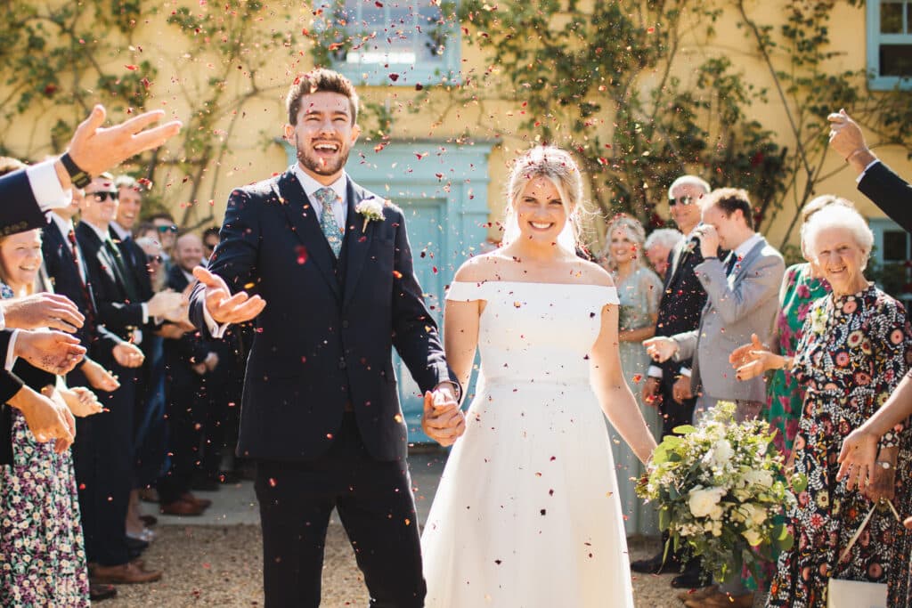Confetti photo of bride and groom in front of guests at countryside wedding venue