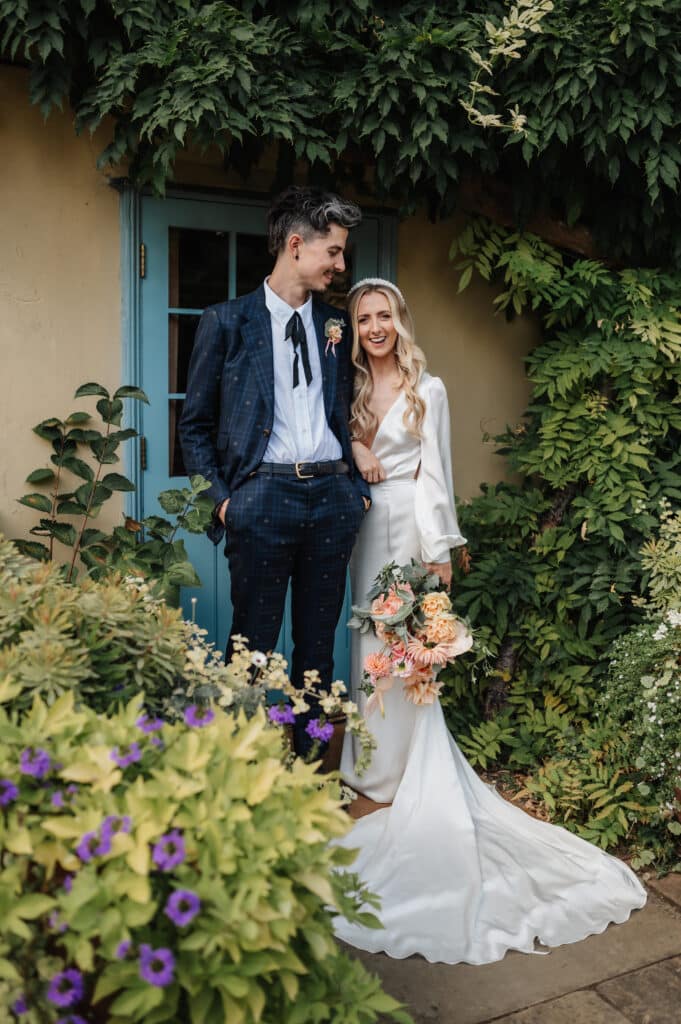 Bride and Groom pose for stunning wedding photo in gardens of country house wedding venue