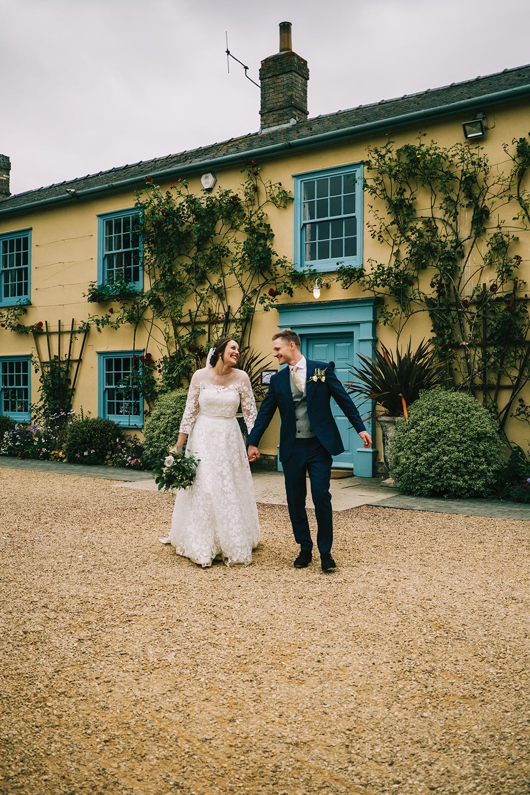 Photo of Bride and Groom in front of  farmhouse at countryside wedding venue 