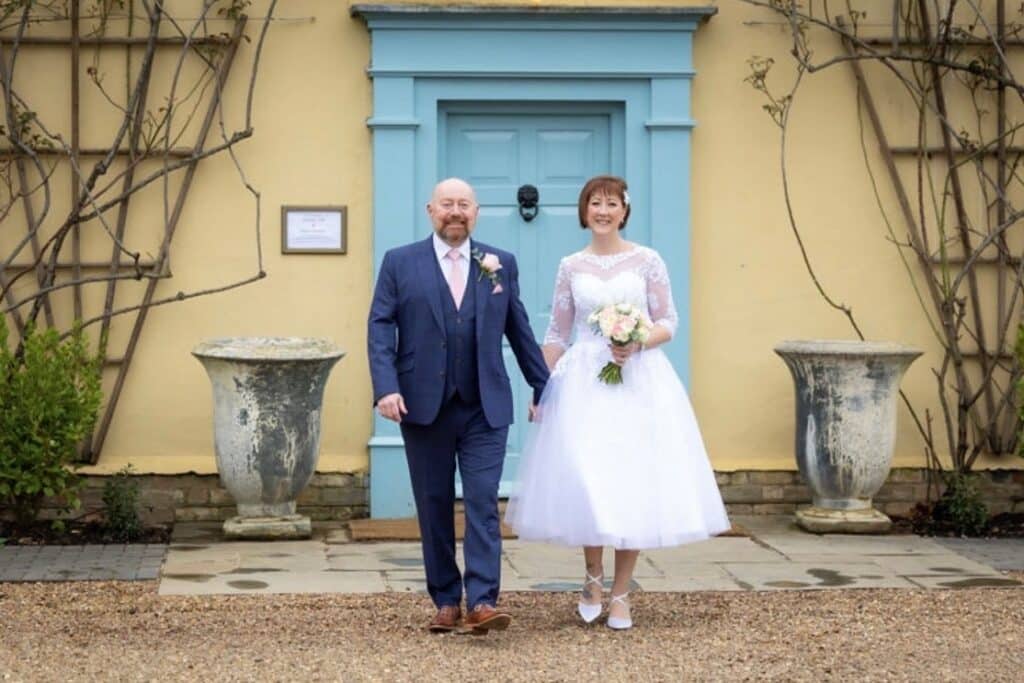 Bride and Groom at Countryhouse wedding venue in front of blue door