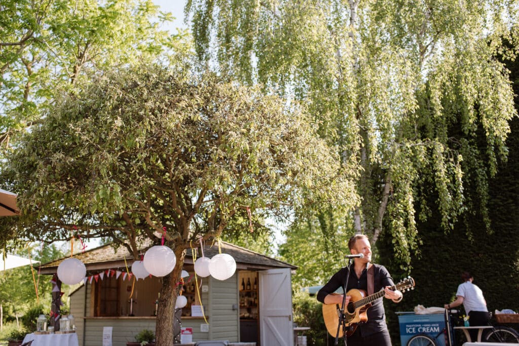 Guitarist plays at garden wedding venue charity event 