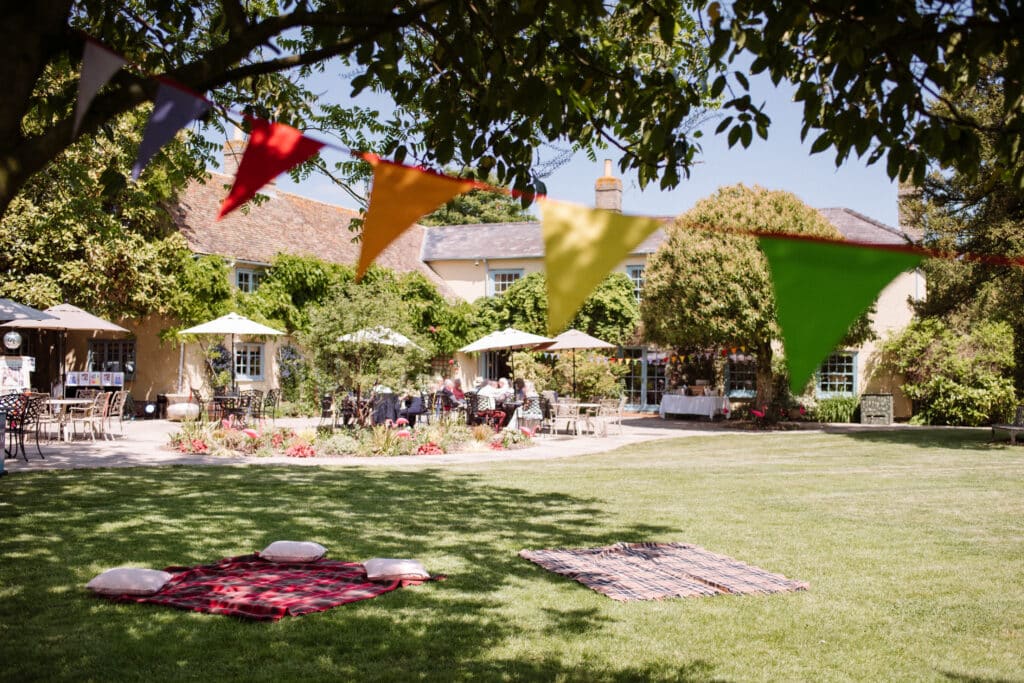 Garden set up for charity event with colourful garden rugs and bunting at countryside wedding venue