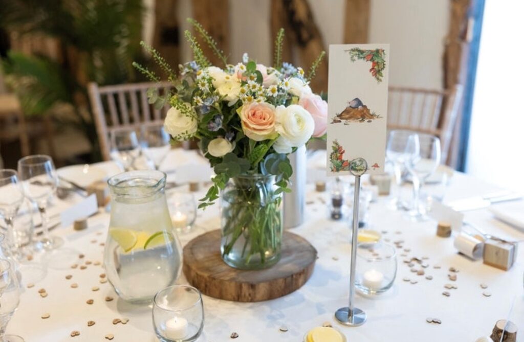 Spring centrepiece flowers in glass vase a barn wedding venue