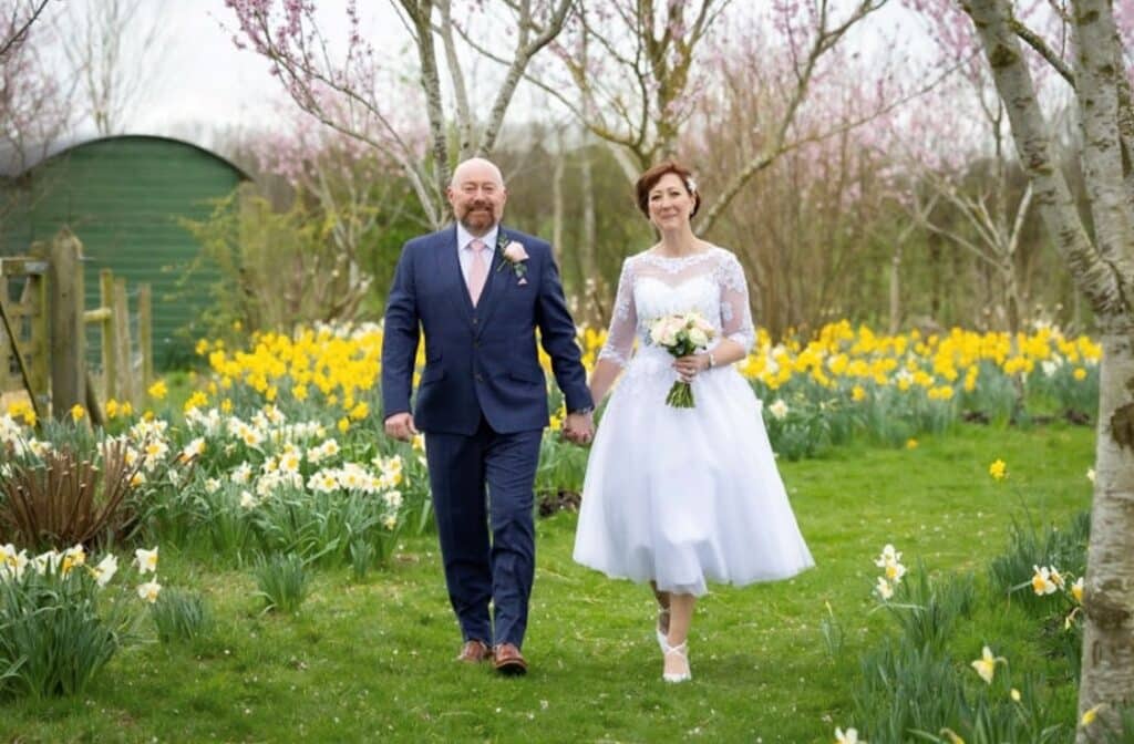 Bride and Groom at Garden Wedding Venue in a field of yellow daffodils 
