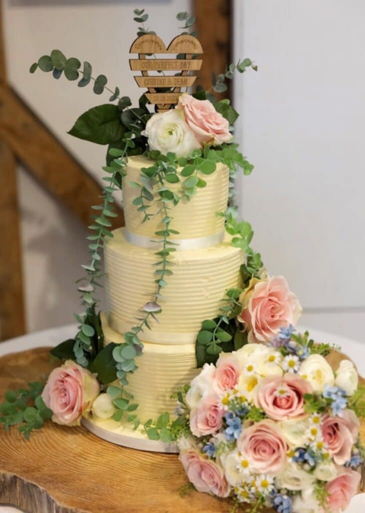 Wedding cake with spring pink and cream flowers and bouquet 