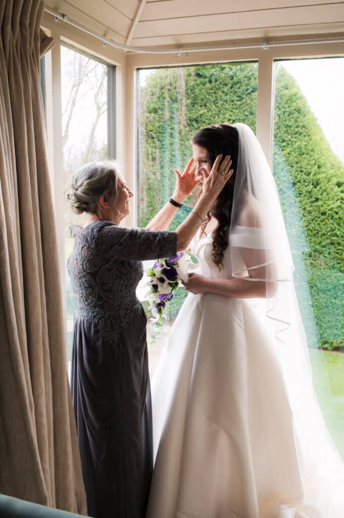 Bride's mother arranges brides veil at Jewish wedding