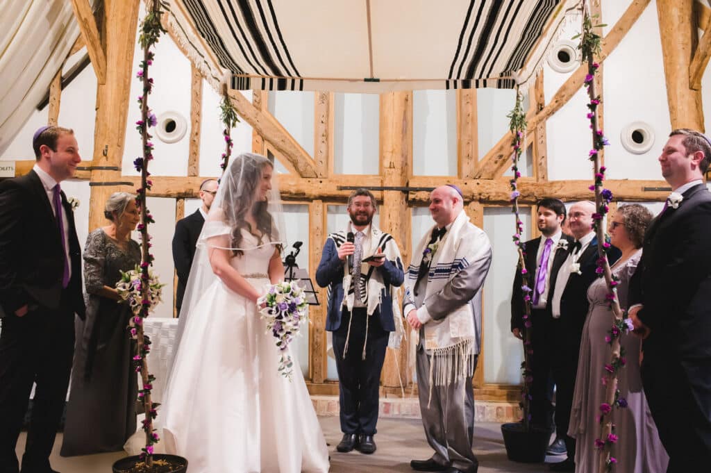 Bride and Groom at Jewish Wedding Ceremony getting married under hand made Chuppah 