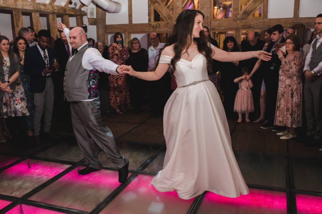 First dance at Jewish Wedding Bride and groom hold hands and dance in front of guests 