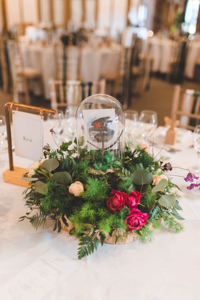 Stunning wedding styling native New Zealand Bird postcards in bell jars in ferns and foliage centrepieces