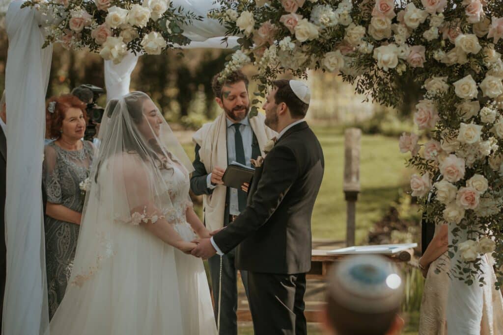 Bride and Groom under Chuppah at Jewish Outdoor Wedding Ceremony