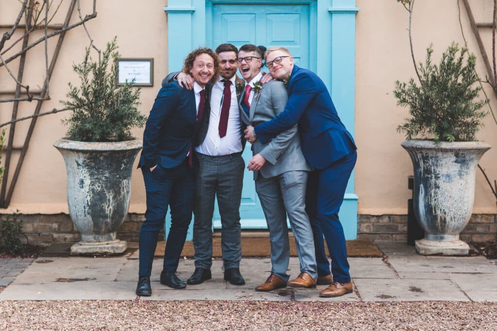 Groom and friends pose for photo at wedding venue
