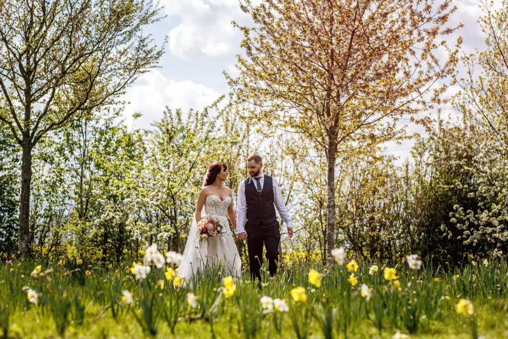 Couple at Spring wedding venue surrounded by daffodils and blossom trees