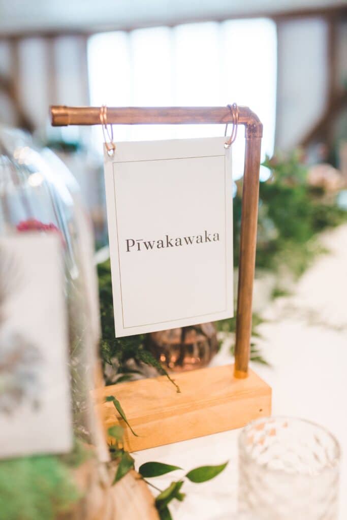 Rustic table names in copper and wood at barn wedding venue