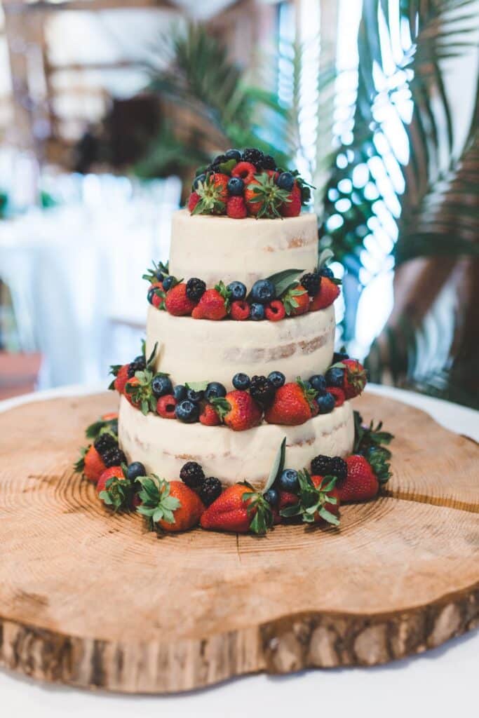 Stunning white iced three tier wedding cake decorated with fruit