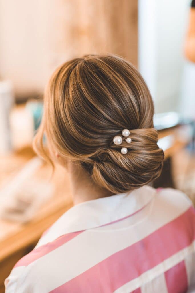 Bridal hair with low bun and stunning pearl clip