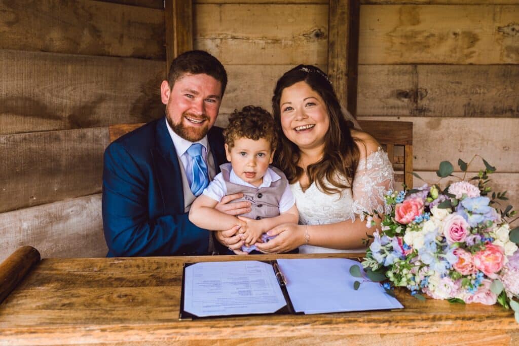 Bride and Groom with their page boy in garden summerhouse on wedding day