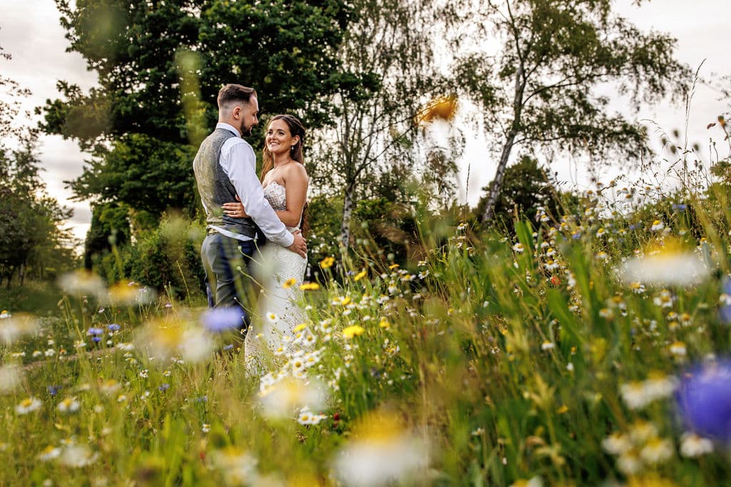Bride and groom in stunning wildflower garden
