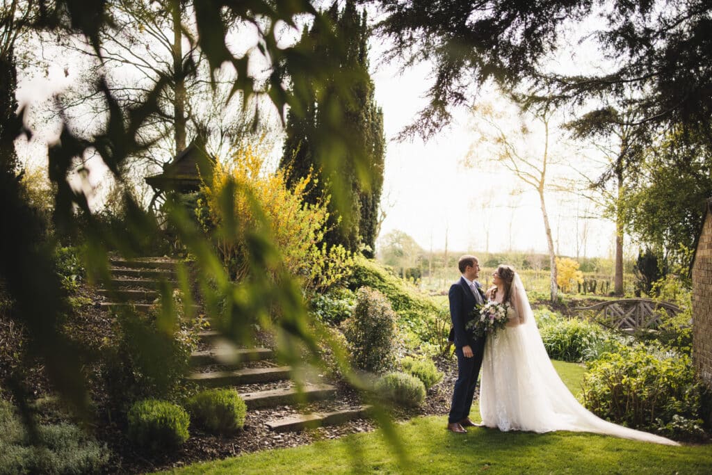 Bride and Groom in outdoor wedding venue at Spring time in beautiful gardens 