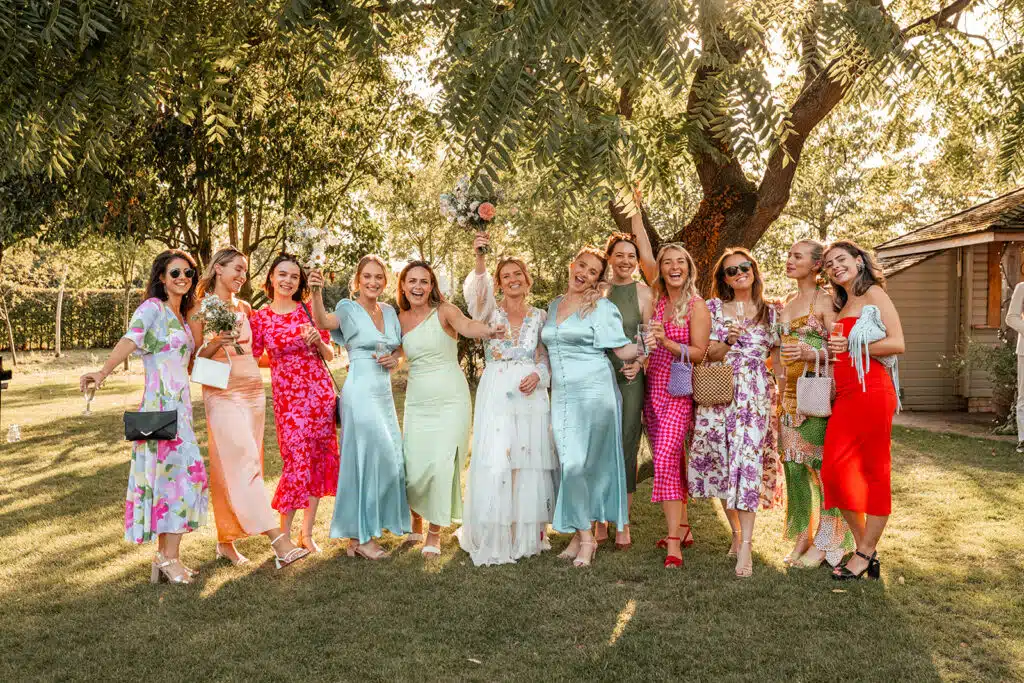Bride and bridesmaids in colourful dresses on a sunny summer wedding day