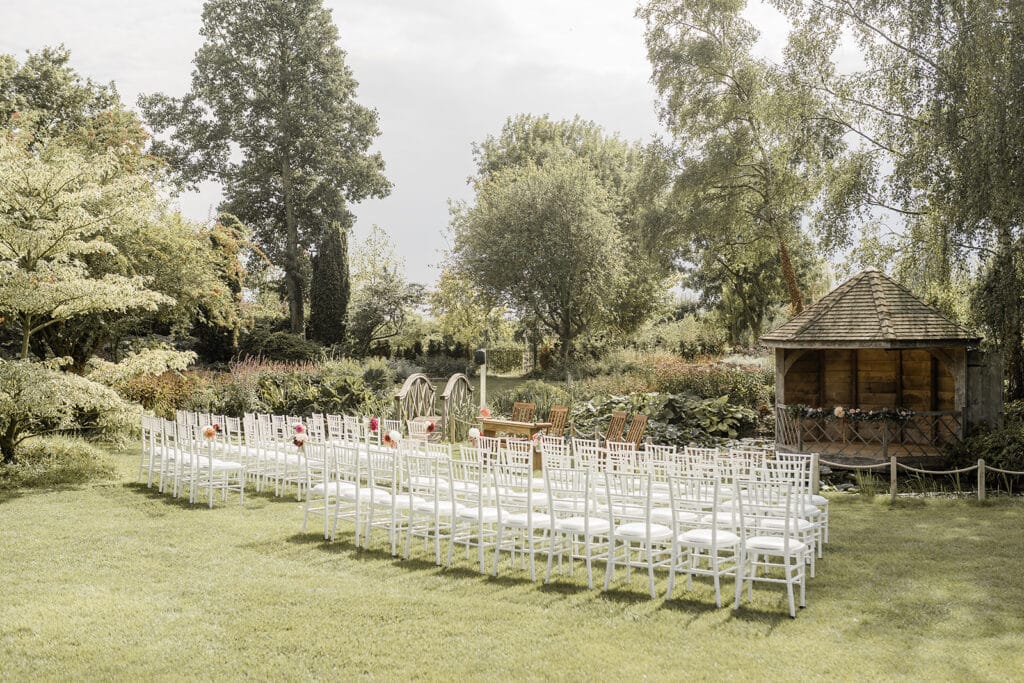 White chairs set for outdoor ceremony at countryside wedding venue on summers day