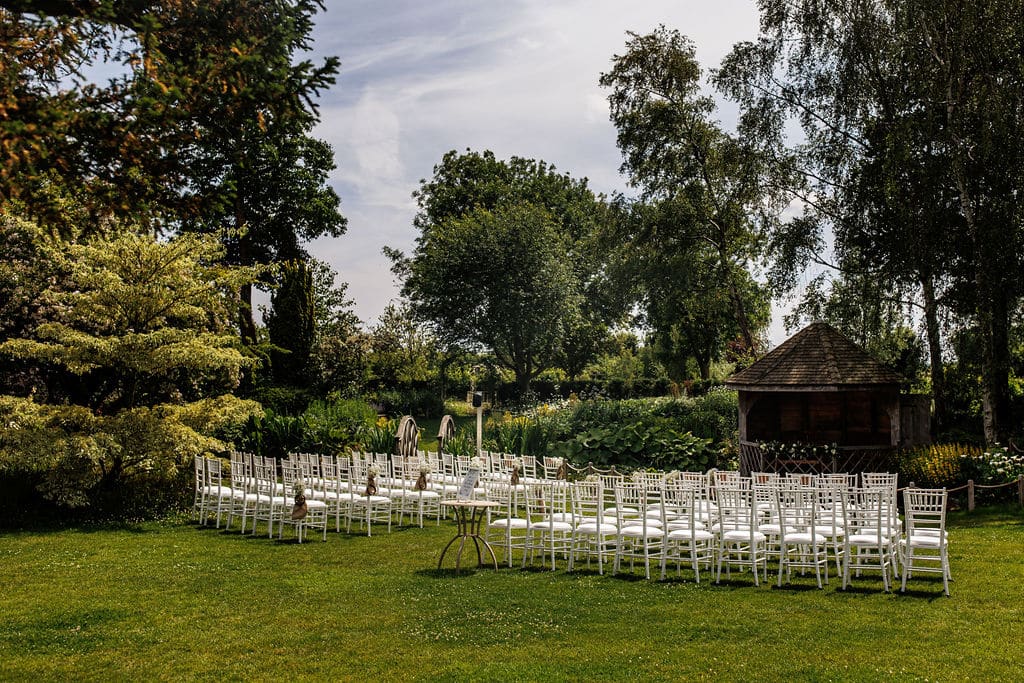 Garden wedding venue set for wedding ceremony with white chairs set on lawn