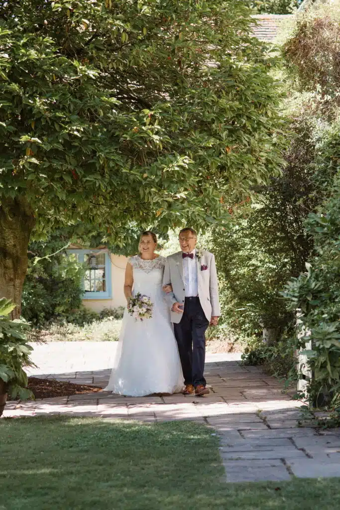 Bride walking towards aisle at garden wedding ceremony