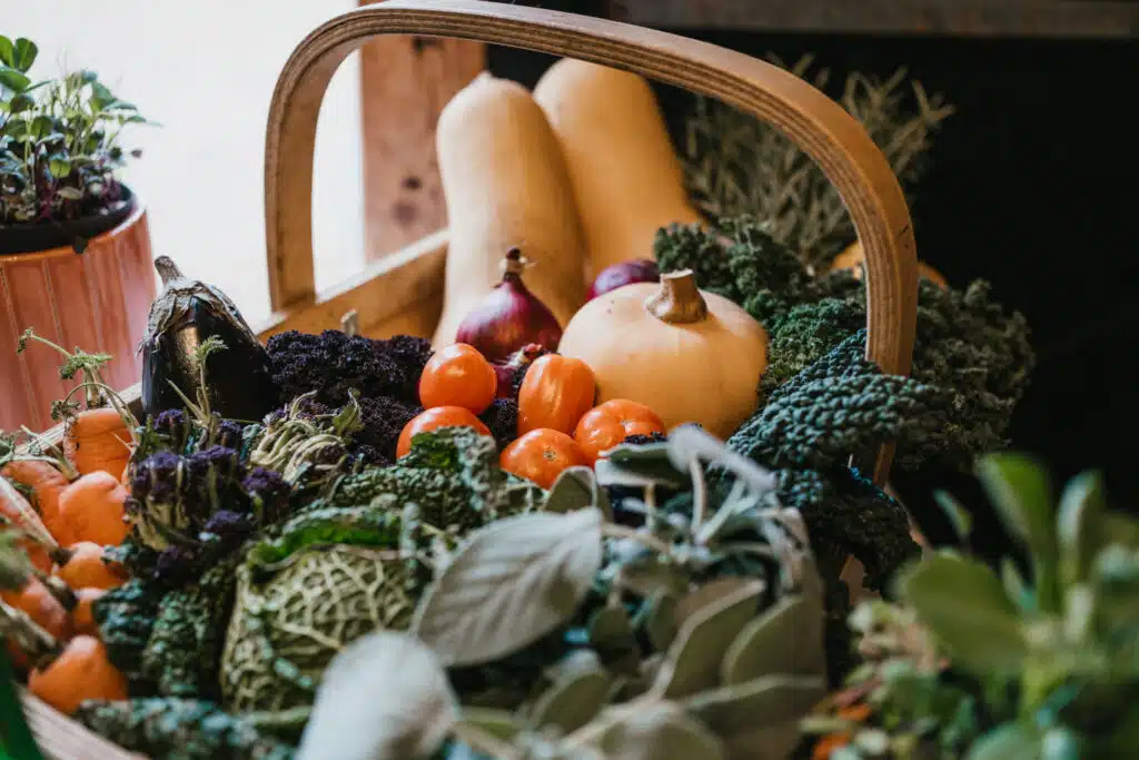 Home grown tomatoes, cabbage, kale and butternut squash in display trug at sustainable wedding venue