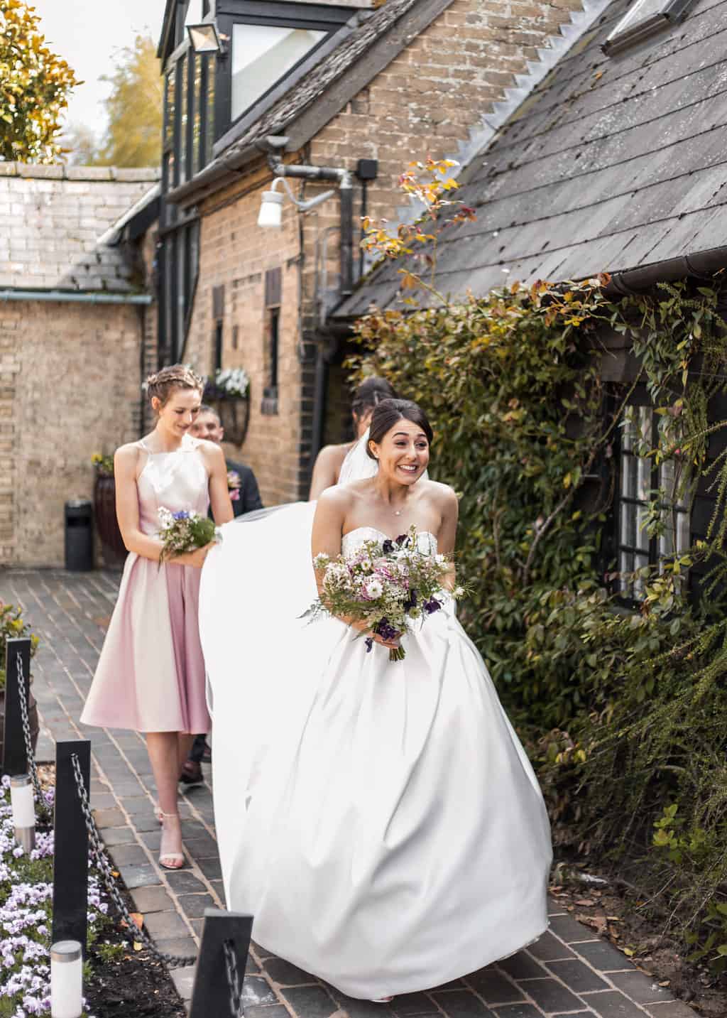 Happy bride holding bouquet outside South Farm wedding venue
