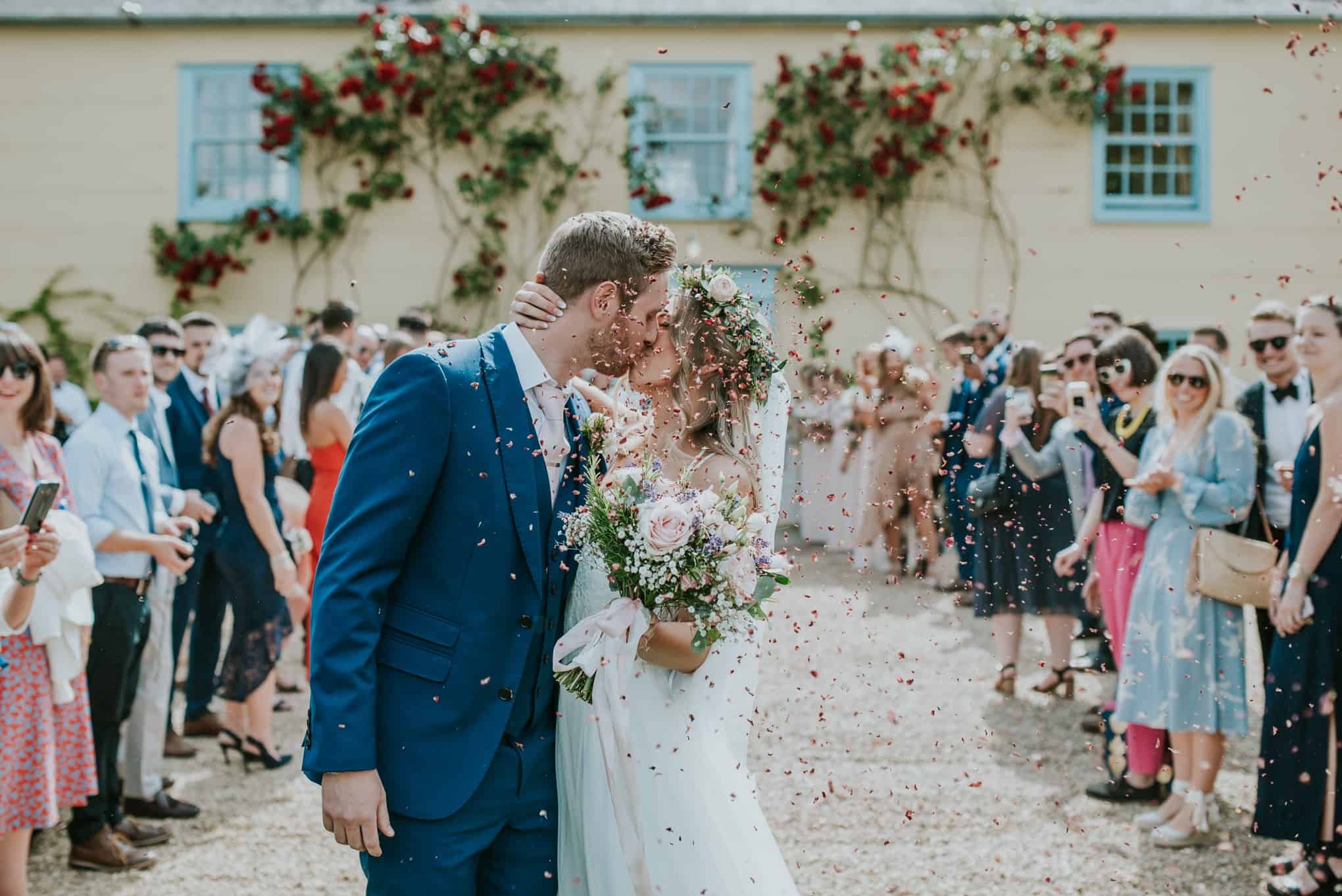Bride and groom kiss in front of wedding venue