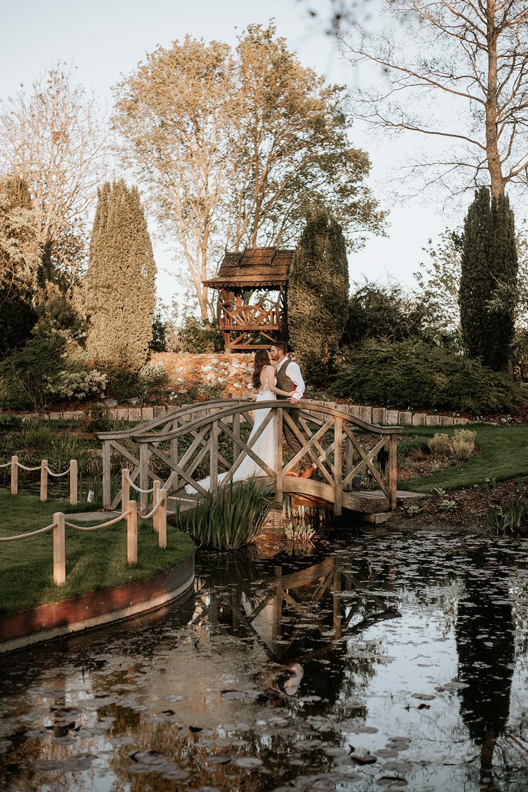 Bride and Groom standing on Monet Bridge at Countryside wedding venue in Hertfordshire